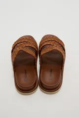 Sandalias planas color negro con tres tiras anchas adornadas con costuras cruzadas en el borde.
