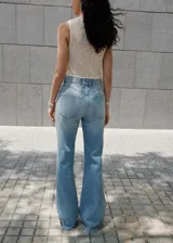 Jeans de tiro medio con diseño flare, confeccionados en tejido de algodón estilo vaquero. Presentan cierre de botón y cremallera, trabillas para cinturón y diseño clásico de cinco bolsillos.