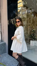 Vestido corto blanco con bordado calado, corte holgado, cuello camisero y mangas 3/4 con volados.