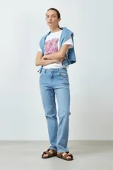 Jean de denim celeste, de corte recto, tiro medio y largo hasta el tobillo.