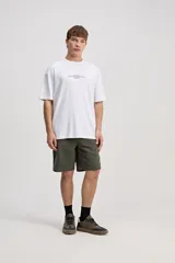 Remera oversize de manga corta color marrón con estampa pequeña en el pecho y estampa geométrica en la espalda.