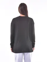 Remera verde oliva de tejido de punto acanalado, con cuello redondo y mangas largas. Detalle de botones en el lateral.