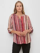 Blusa de gasa con estampado de rayas verticales en tonos rojos, naranjas y cremas. Presenta cuello mao con escote en V, abertura frontal con botones y mangas largas con presilla para regular el largo.