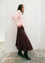 Falda midi plisada de cuero sintético en color bordó, con diseño de talle alto y corte recto.