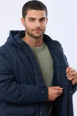 Campera de abrigo color azul marino, con capucha desmontable, cierre frontal con solapa, bolsillos frontales con solapa y detalle de etiqueta de cuero sintético. Cuenta con interior forrado en corderito en la parte superior para mayor calidez.