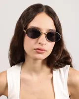 Lentes de sol ovalados con marco dorado y lentes oscuros.
