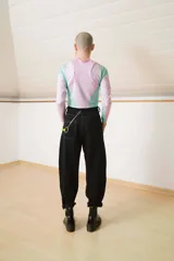 Pantalón negro de corte recto con costuras blancas contrastantes y detalle de cordones cruzados en la cintura.