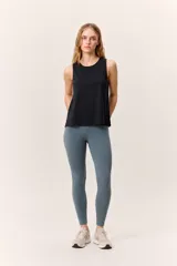 Musculosa deportiva negra de corte holgado, con cuello redondo y aberturas laterales en el ruedo.