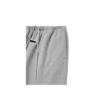 Pantalón de jogging gris claro Fear of God Essentials, corte flare y diseño de pernera ancha, con cintura elástica con cordón de ajuste extralargo y etiqueta de goma con el logo de la marca en la parte frontal.
