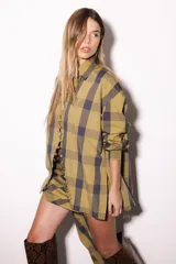 Camisa oversize a rayas celestes y blancas, con cuello camisero, manga larga y hilera de botones dorados metálicos.