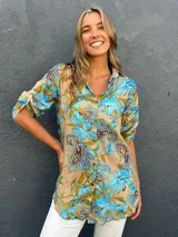 Sobrecamisa de algodón y viscosa con estampado floral y paisley en tonos turquesa, camel y marrón chocolate, con cuello camisero y cierre frontal de botones.