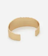 Pulsera tipo brazalete rígido con diseño de espiral ondulado y acabado en tono dorado. Presenta una abertura frontal que permite un ajuste cómodo a la muñeca.