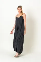 Enterito de viscosa color negro, con diseño holgado y piernas anchas. Presenta escote en V con detalle de satén y breteles finos.