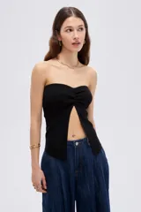 Top de viscosa negro, sin mangas, con escote strapless y frunce central en el escote que genera una abertura frontal.