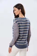 Buzo tejido de algodón con diseño a rayas horizontales, cuello redondo y mangas largas. El cuerpo presenta rayas en tonos azul y beige, mientras que las mangas combinan rayas en tonos azul y rosado.