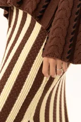 Pollera larga tejida a rayas verticales color chocolate y crema, con pretina elástica y tajos laterales.