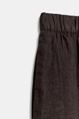 Pantalón de tiro medio confeccionado en lino, con cintura elástica y diseño de pierna ancha tipo barrel. Cuenta con bolsillos laterales.