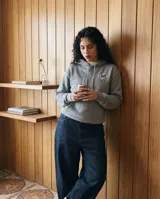 Canguro con capucha de calce regular en color gris con efecto stone wash. Presenta un estampado gráfico en la espalda con estilo de cómic que incluye la palabra 'BO!' en un globo de texto y diversos dibujos.