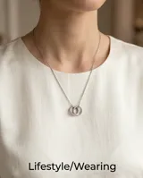 Collar de acero con cadena fina y dos dijes circulares entrelazados, uno de ellos con incrustaciones de circonias.