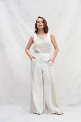 Pantalón de lino color beige y blanco, de corte amplio a la cintura y con bolsillos laterales.