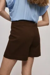 Short cruzado de tiro medio con diseño frontal tipo falda, color negro, de líneas simples y calce cómodo.