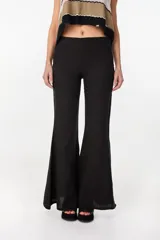 Pantalón oxford color negro, confeccionado en lino italiano, de talle medio con diseño ajustado en la parte superior y silueta acampanada en la parte inferior.