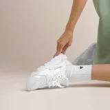 Championes Nike Air Huarache blancos, con ajuste tipo botín, clip icónico en el talón y suela de goma.