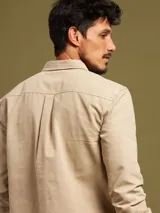 Camisa de manga larga color azul con dos bolsillos frontales con botón.