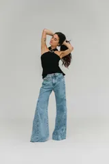 Blusa de crepe twill color blanco, con escote halter y detalle de hebilla metálica dorada en el cuello.