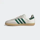 Championes Adidas modelo Samba OG, con diseño clásico de perfil bajo. Presentan una base de cuero color crema con superposiciones de gamuza gris en la puntera y los ojales. Incluyen las icónicas tres rayas laterales y el detalle en el talón en color verde oscuro, con suela de goma color caramelo.