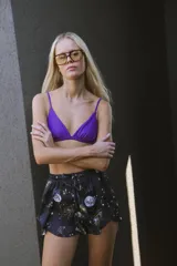 Short negro de satén estampado con lunas, estrellas y galaxias. Tiene cintura elastizada, cordones para ajustar y tiro alto.