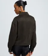 Campera bomber de gamuza sintética color verde oliva, con cuello estructurado, cierre frontal con botones metálicos y bolsillos delanteros con solapa.