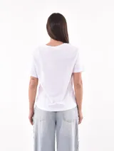 Remera blanca de manga corta y corte holgado, con estampa frontal que incluye flores azules y el texto "SPRINGTIME".