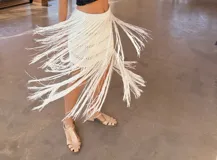 Falda midi tejida de algodón en punto acanalado, color gris, con diseño de flecos largos que aportan movimiento y tajo lateral.