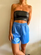 Short de cuero sintético celeste con cintura elástica y cordón ajustable.