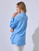 Camisa amarilla con bordado floral, cuello con solapa, abertura central con botones y bolsillo aplicado en el pecho.