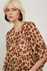 Camisa de manga corta con estampado animal print, cuello bote, abotonada en el frente y de fit amplio.