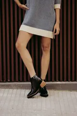 Botín de cuero color beige con puntera charolada, cierre lateral con cremallera y tacón ancho de madera.