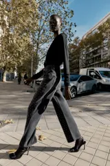 Jeans de tiro alto, corte recto y largo, color negro lavado, con abalorios brillantes distribuidos por toda la prenda.