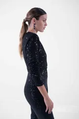 Mono largo negro con lentejuelas, escote en V cruzado, mangas largas y corte ajustado.