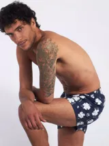 Bóxer de algodón blanco con estampado de flores pequeñas color celeste, con cintura elástica y logo de la marca en el centro.