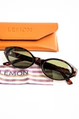Lentes de sol con armazón ovalado de acetato negro y micas oscuras.
