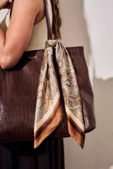 Bandana cuadrada de poliéster con estampado paisley en tonos marrones, beige y crudo, con bordes anchos en degradé marrón.