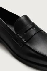 Mocasín de vestir negro fabricado en cuero, con detalle de antifaz en el empeine, suela a tono y ligero tacón.