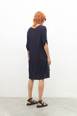 Vestido azul marino con estampado abstracto en blanco y celeste, escote en V y mangas cortas.