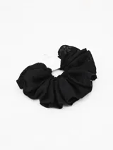 Colero de tela negro con textura y volantes.