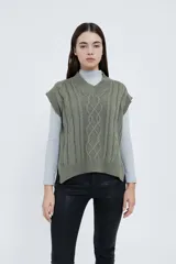 Chaleco tejido color verde oliva con cuello en V y diseño de trenzas.