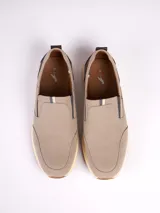 Zapatilla tipo slip-on marca Polanco, color beige con detalles en marrón oscuro en el talón. Presenta una capellada de tela, suela de goma color crema y etiqueta de la marca en el lateral.