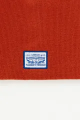 Gorro tipo beanie de tejido de punto color naranja, con parche rectangular con el logo clásico de Levi's Strauss & Co. en la parte frontal.