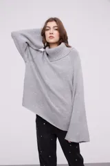 Sweater de punto con cuello alto tipo polera, de calce holgado y mangas largas con diseño acampanado.